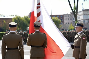 Poczet sztandarowy wciągający flagę.
