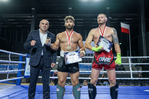 Dwóch zawodników w ringu z medalami, dyplomami i wręczającym medale.