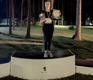 Policjantka stoi na podium, w rękach trzyma dyplom i statuetkę.