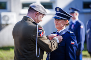 Doradca Prezydenta zawiesza medal wyróżnionej policjantce.