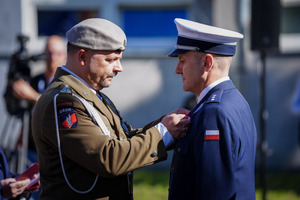 Doradca Prezydenta zawiesza medal wyróżnionemu policjantowi.