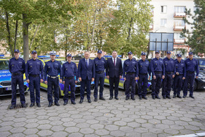 Policjanci stoją wraz z zaproszonymi gośćmi.