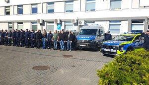 Policjanci oddają hołd zmarłemu Koledze. Umundurowani funkcjonariusze stoją przy radiowozach.