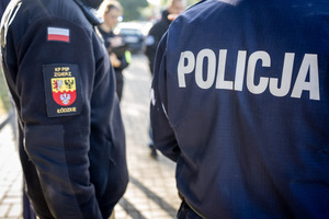 Policjant stoi obok strażaka.