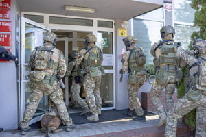 Policjanci z Samodzielnego Pododdziału Kontrterrorystycznego Policji wchodzą do budynku.