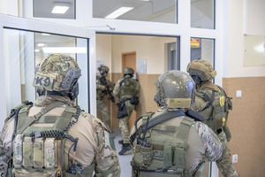 Policjanci z Samodzielnego Pododdziału Kontrterrorystycznego Policji wchodzą do pomieszczenia.