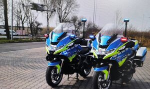 Bezzałogowy Statek Powietrzny Policji obok dwóch motocykli.