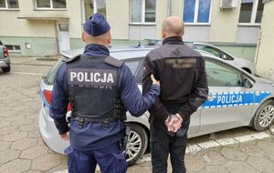 Funkcjonariusz policji z osobą poszukiwaną.