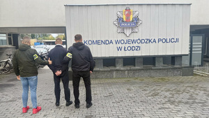 Funkcjonariusz policji z osobą poszukiwaną.