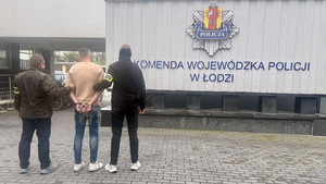 Funkcjonariusz policji z osobą poszukiwaną.