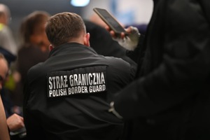 Funkcjonariusze Policji i Straży Granicznej podczas legitymowania osób.