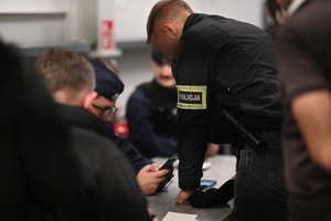 Funkcjonariusze Policji i Straży Granicznej podczas legitymowania osób.