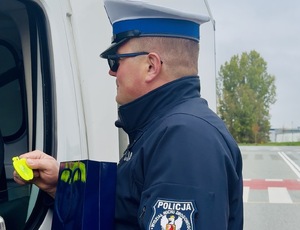 Policjant rozdający odblaski.