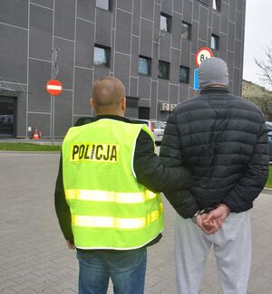 policjant prowadzi zatrzymanego