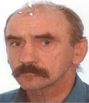 Mężczyzna w wąsach z częściową łysina w niebieskiej koszuli.