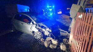 Droga, samochód rozbity przy płocie z tyłu radiowóz policyjny.