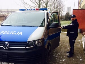 Policjant przy radiowozie.