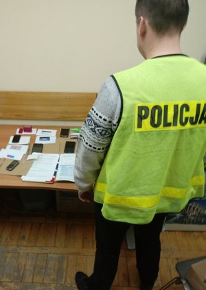 policjant podczas oględzin zabezpieczonych dokumentów