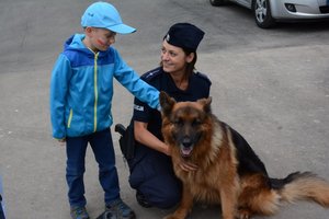 policjanta z psem sluzbowym uczy dzieci bezpiecznych zachowań