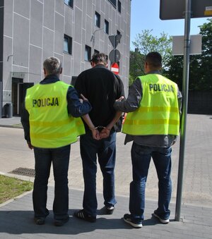 policjanci konwojują zatrzymanego