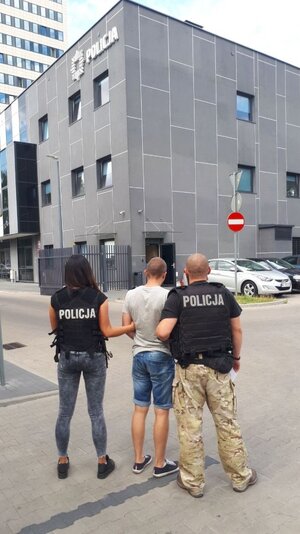 policjanci prowadzą zatrzymanego