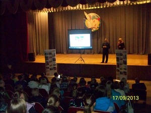Zdjęcie dwojga prelegentów na scenie obok ekranu z wyświetloną prezentacją