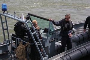 Zdjęcie czterech umundurowanych uczestników na policyjnej jednostce pływającej