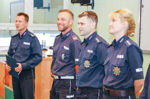 Trzech policjantów i policjantka stoją w rzędzie.