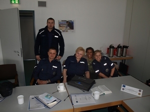 Zdjęcie pięciorga uczestników na sali wykładowej przy stole