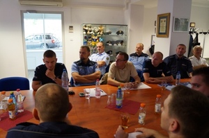 Zdjęcie uczestników zajęć wartsztatowych przy stole w sali wykładowej