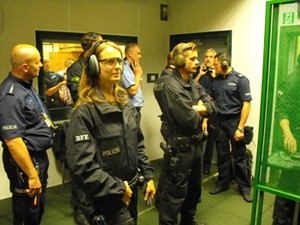 Zdjęcie kilkuosobowej grupy uczestników w ochraniaczach na uszy i z bronią - przygotowujących się do ćwiczeń