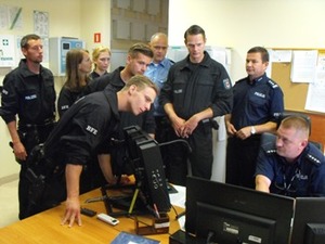 Zdjęcie ośmioosobowej grupy uczestników obserwujących stanowisko dyżurnego w czasie pracy (obsada jednoosobowa)