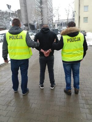 Policjanci prowadzą zatrzymanego.