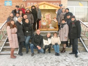 Zdjęcie przedstawiające przedstawicieli strony polskiej i ukraińskiej stojących na tle malowidła typu ikonograficznego oraz budynku z cegły