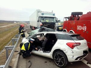 Policjant przy wraku rozbitego auta.