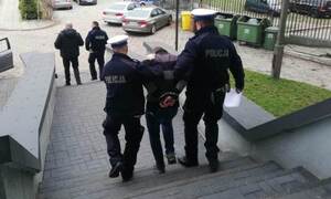 Policjanci prowadzą zatrzymanego.