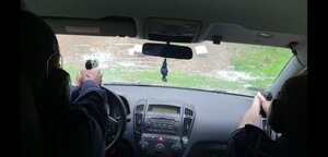 widok z wnętrza radiowozu.,widać przednią szybe, dwóch policjantów siedzi na przednich siedzeniach , jeden z nich celują bronią