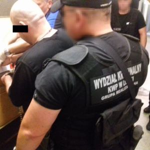 widac podejrzanego podeczas daktytolskopii a za nim policjant wydziału kryminalnego KWP w Łodzi