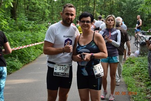 zwycięzcy biegu kom. Beata Nienadowska i nadkom. Robert Kowalski.Oboje w strojach sportowych na tle trasy biegu pokazuja medale.