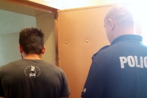 Policjant prowadzi zatrzymanego