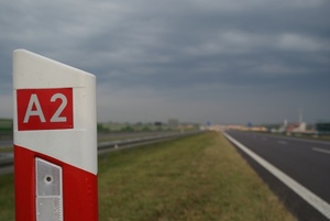 Zdjęcie słupka autostradowego z napisem "A2" - w tle rozmyty widok autostrady