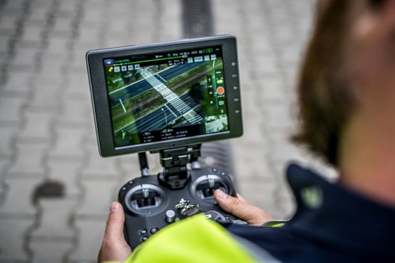 policjant trzyma monitor podglądu kamery drona