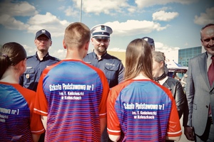 dzieci stojące przed policjantami podczas odbierania nagród