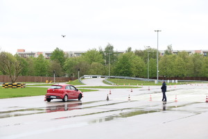 jazda samochodem, jedna z konkurencji podczas konkursu Policjant Ruchu Drogowego. Na zdjęciu samochód na torze i policjant nadzorujący prawidłowy przebieg konkursu.