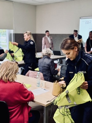 Policjantki wręczają seniorom odblaski.