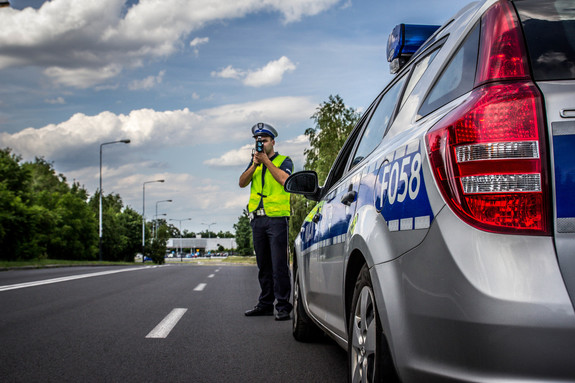 Policjant mierzy prędkość na drodze.