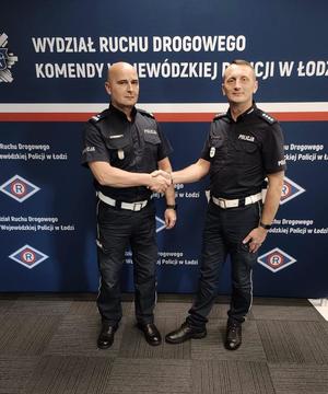 Naczelnik Wydziału Ruchu Drogowego wraz z innym policjantem na ściance.