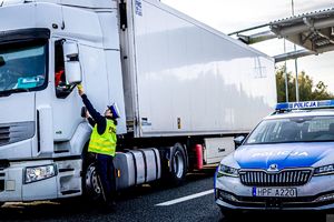 Policjantka sprawdza stan trzeźwości kierującego ciężarówką.