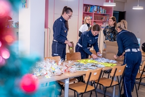 Policjanci pakują prezenty dla dzieci.