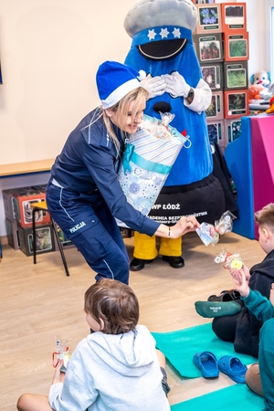 Policjantka wręcza dzieciom prezenty.